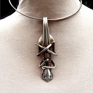 Cross leg cello player bent fork pendant necklace, flower motive